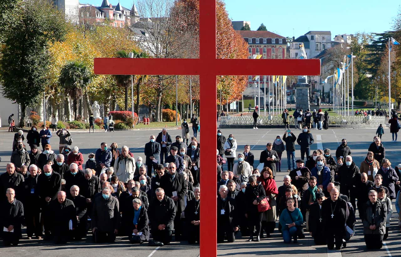 Bishops and nuns make a penitential gesture on the forecourt of the Notre-Dame-du-Rosaire basilica 