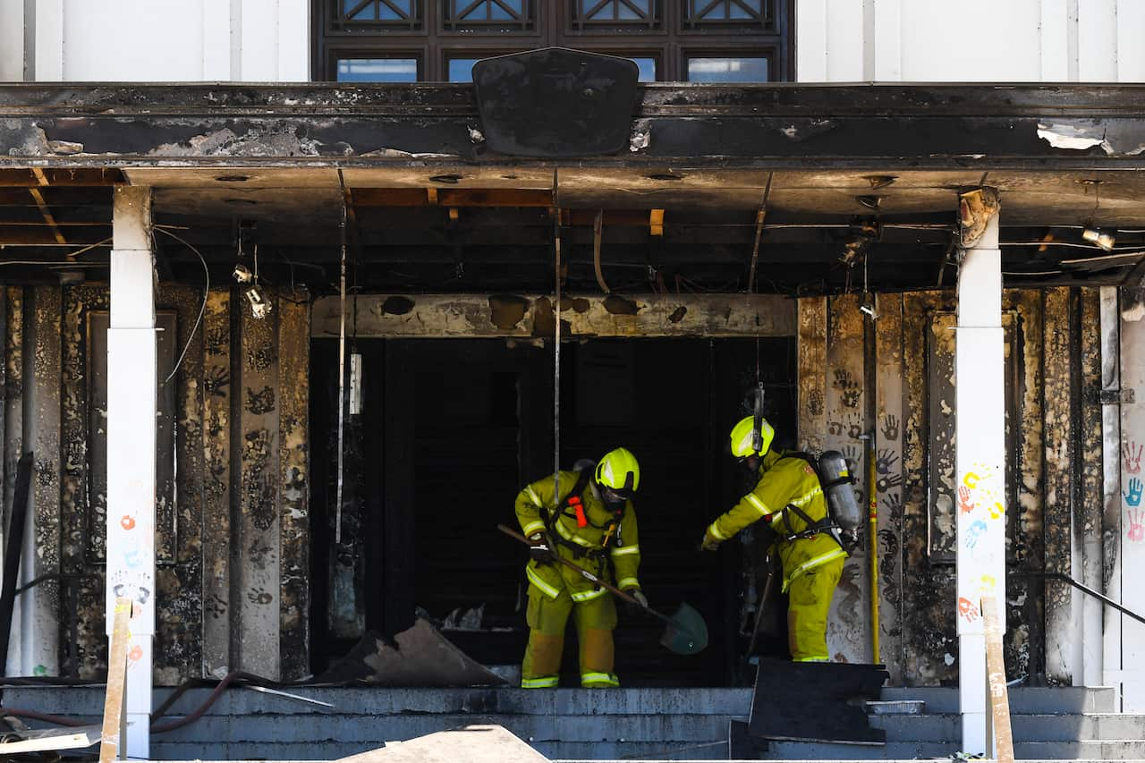 Firefighters are seen entering the fire damaged entrance to Old Parliament House in Canberra