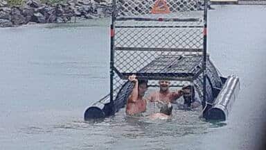 The Department of Environment and Heritage Protection is investigating the men who took this picture after getting inside a crocodile trap.