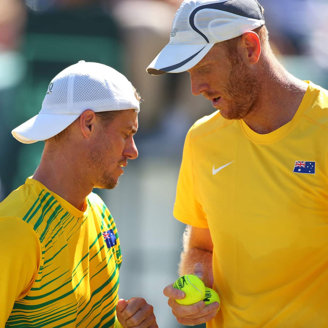 Lleyton Hewitt talks with Chris Guccione in their Davis Cup doubles match.