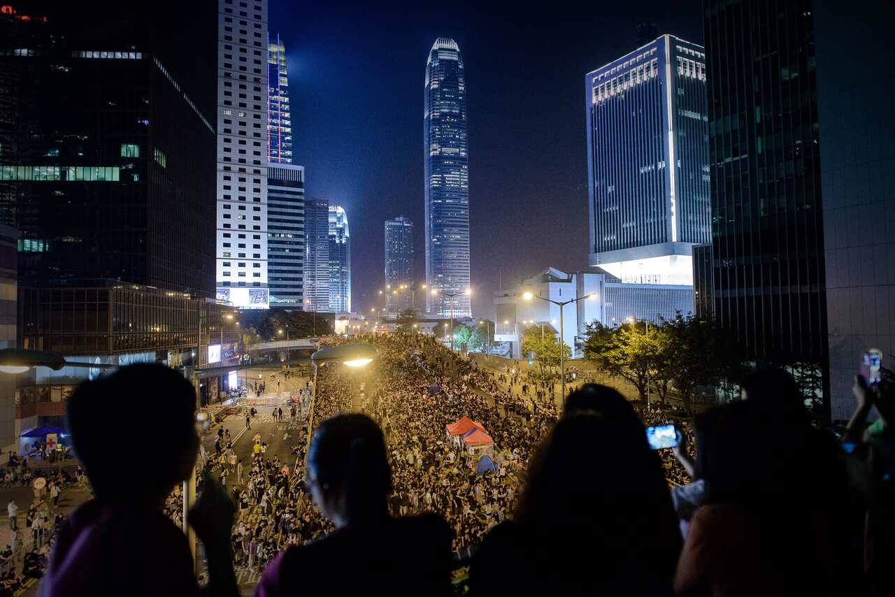 People watch as massive crowds of pro-democracy demonstrators gather for a night rally in Hong Kong on October 4, 2014. (AFP/Getty)