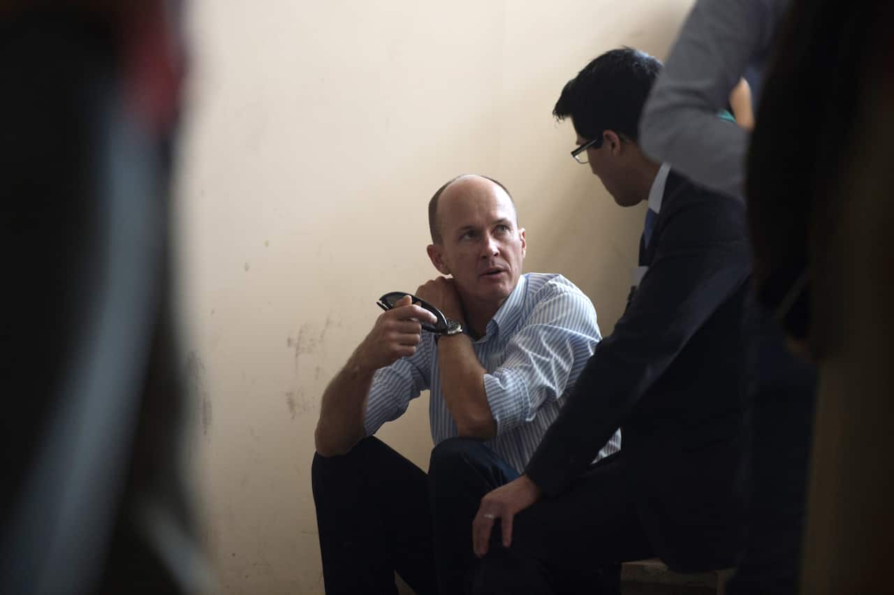 Andrew Greste, brother of the Australian journalist Peter Greste of Al-Jazeera, talks sitting on stairs during the trial of his brothe on March 5, 2014. (AFP/Getty Images)
