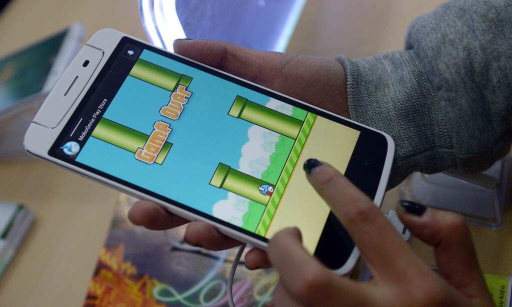 An employee plays the game Flappy Bird at a smartphone store in Hanoi on February 10, 2014.