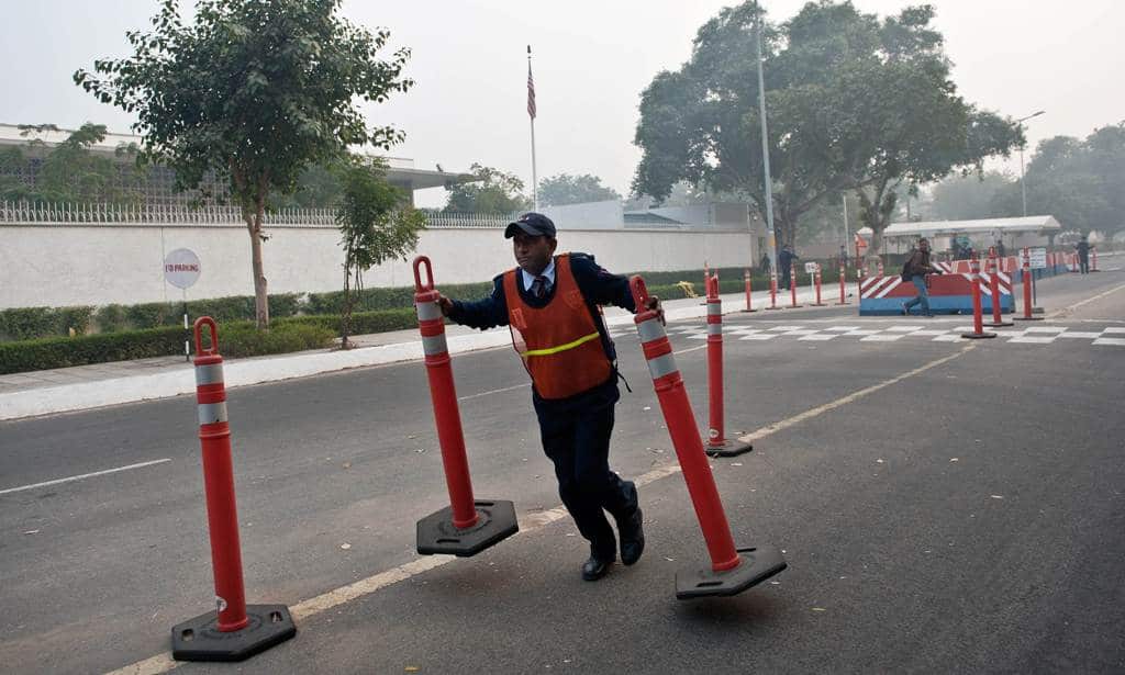 A US Embassy security guard removes a road-barrier in front of the US Embassy in New Delhi on December 17, 2013. (AAP)