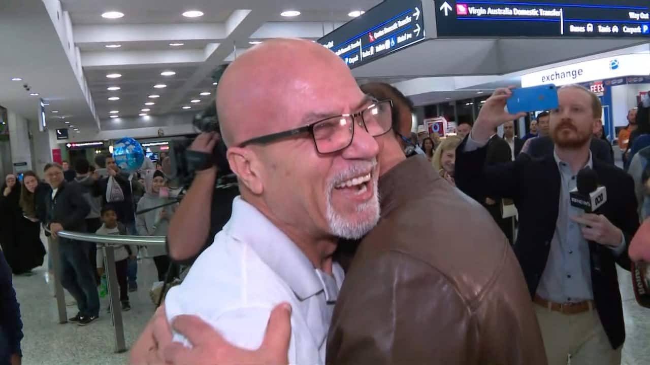 Naim Aziz Abbas, an Iraqi-born former Sydney train driver who was jailed in the UAE, embraces his brother after touching down in Sydney.