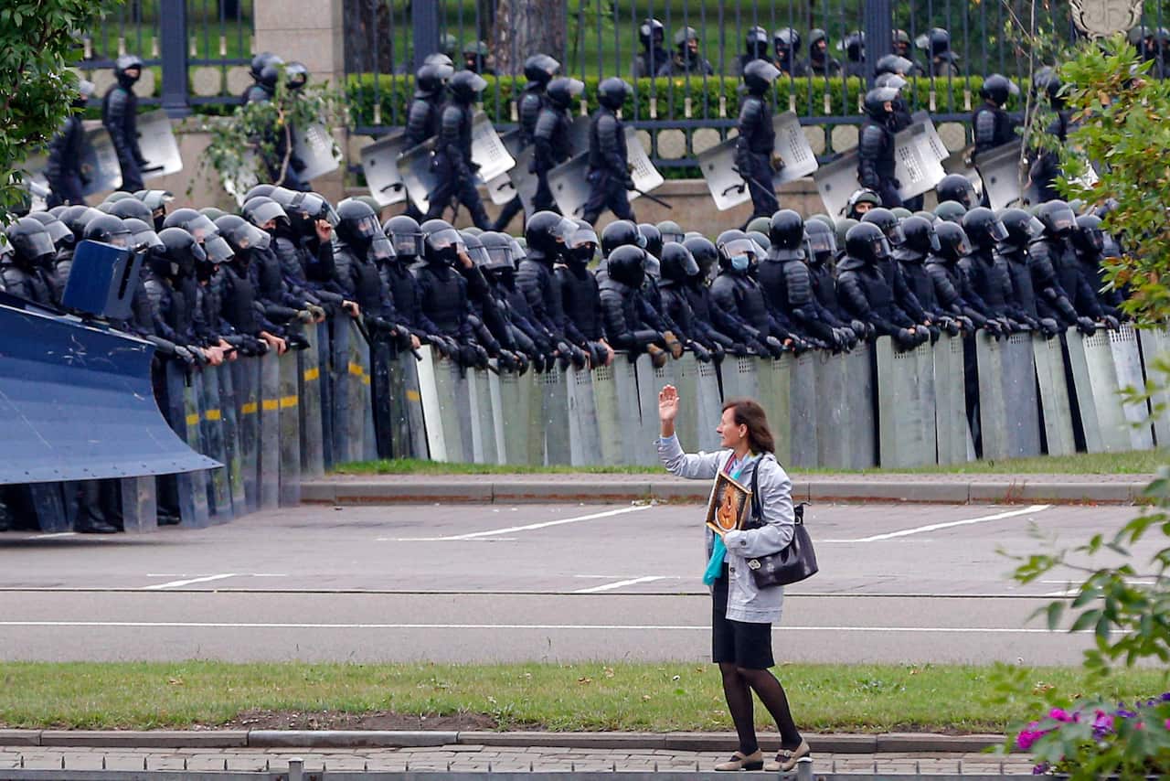 A woman gestures in front of a riot police blockade (AAP)