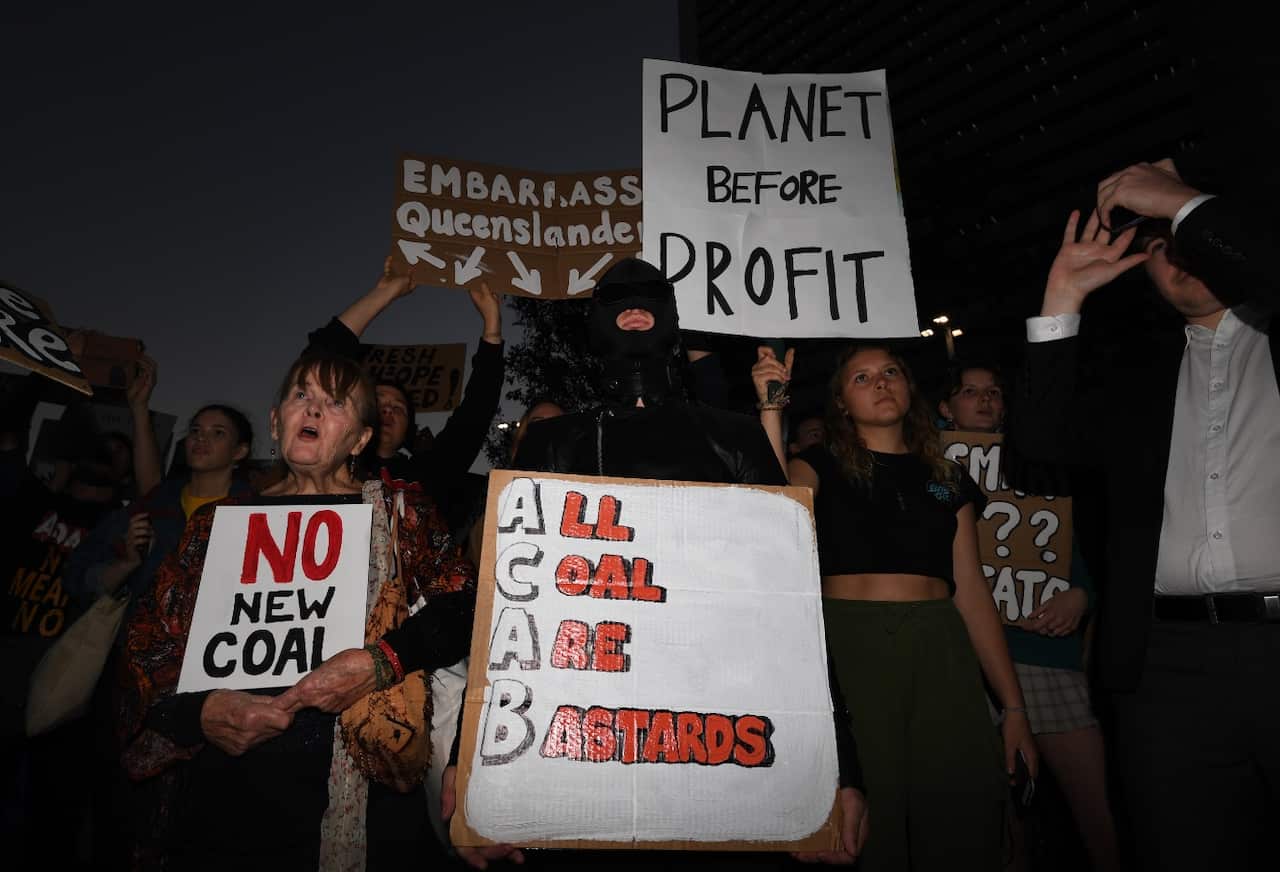 Protesters opposing to the construction of the Adani coal mine hold signs during a rally in Brisbane, Friday, June 21, 2019. 