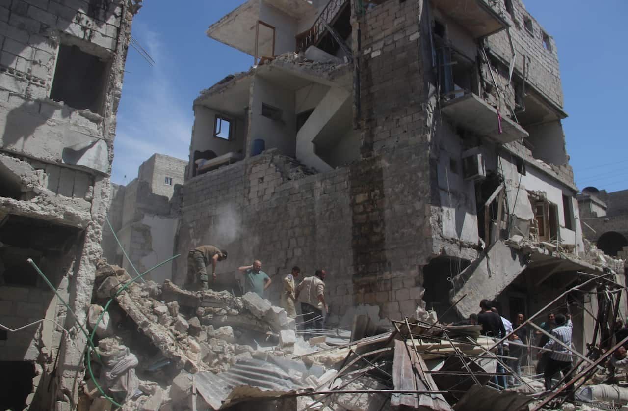 Civilians look for survivors under debris around wracked building after Russian forces staged air-strike over Aleppo's opposition controlled Kellase (Getty)