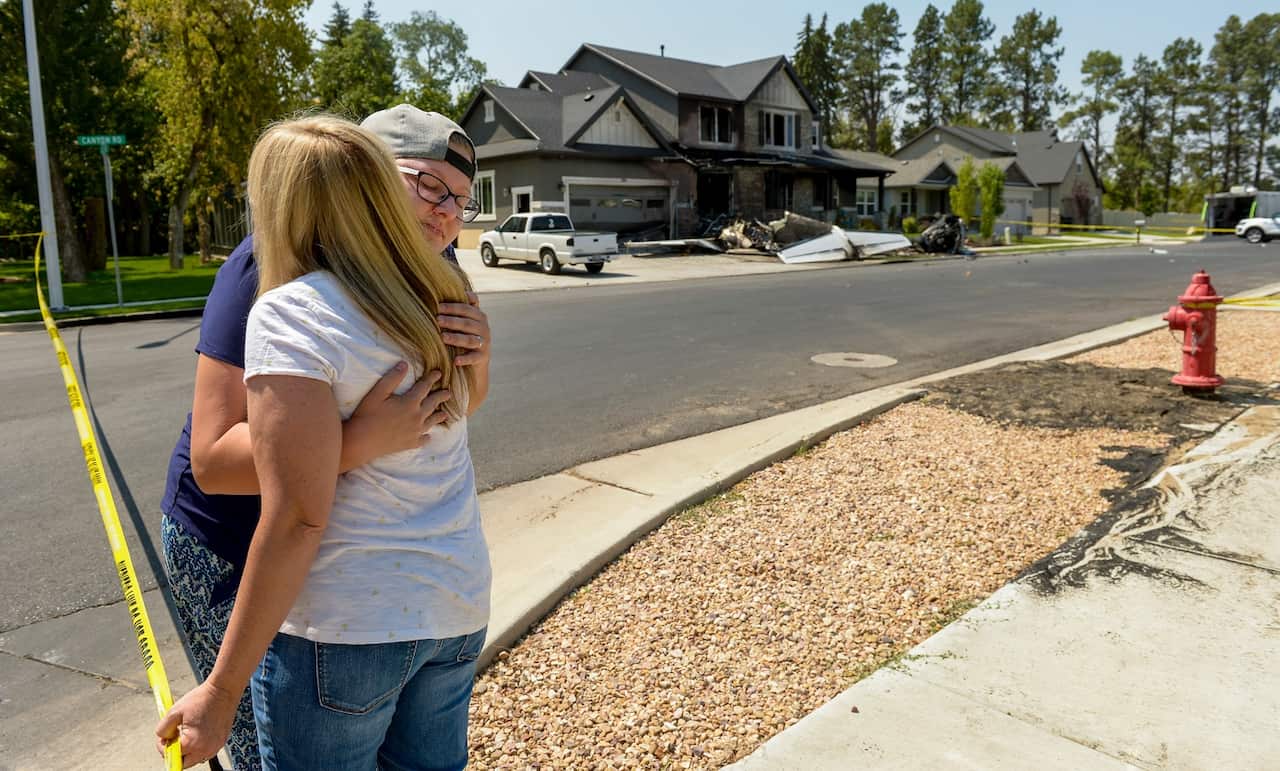 Joslyn Youd, 21, gets a hug from her aunt Nikki Ewell outside a damaged house