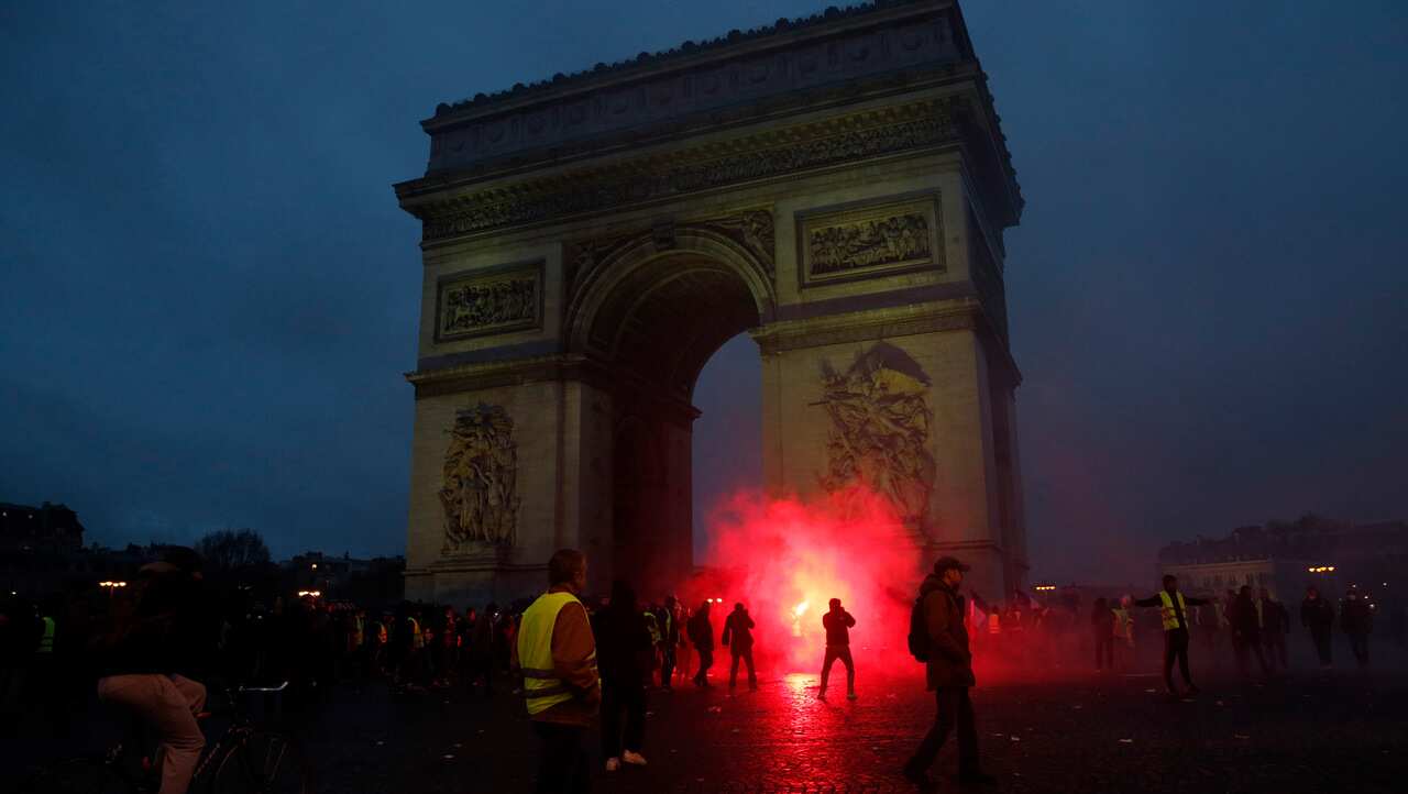 Protesters wave flares.