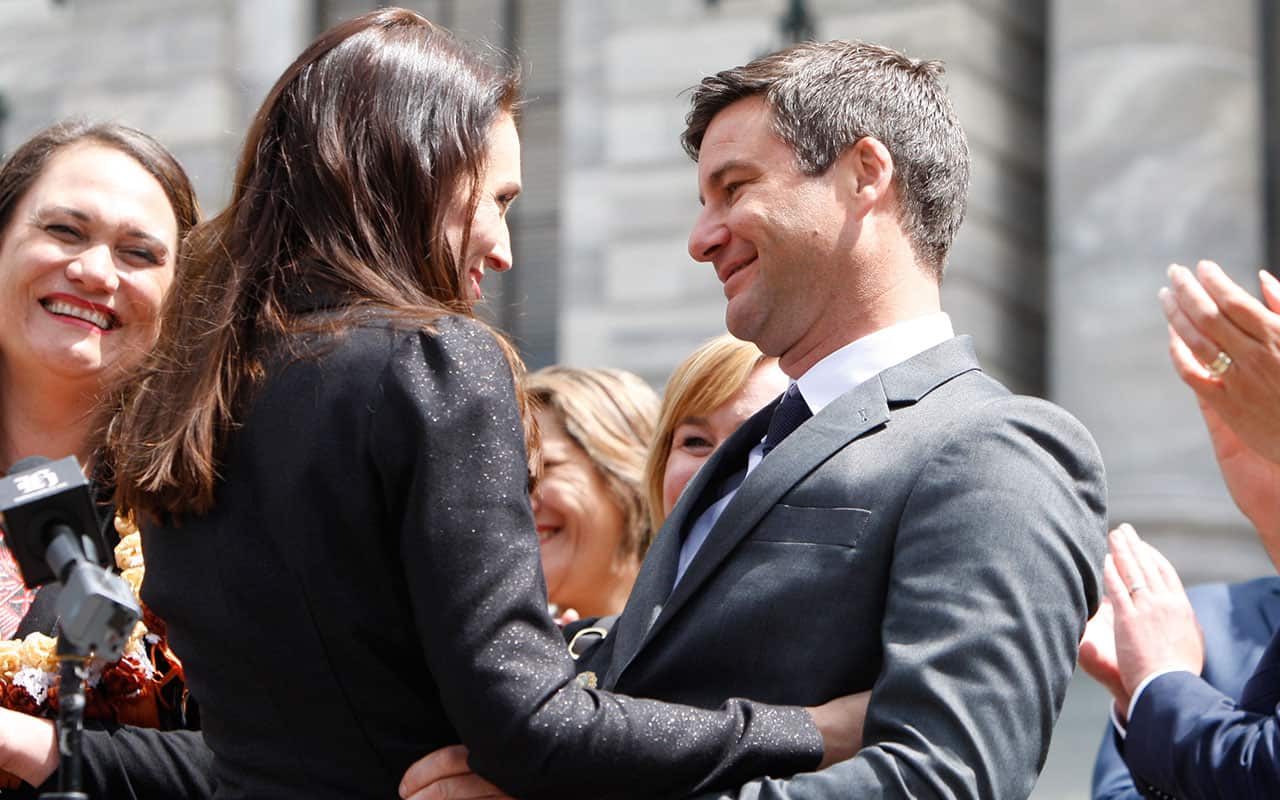 New Zealand Prime Minister Jacinda Ardern, center left, embraces her partner Clarke Gayford after speaking to well-wishers