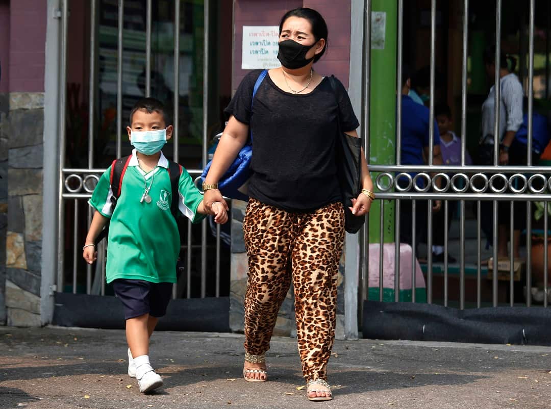A mother and her son wear protective masks.