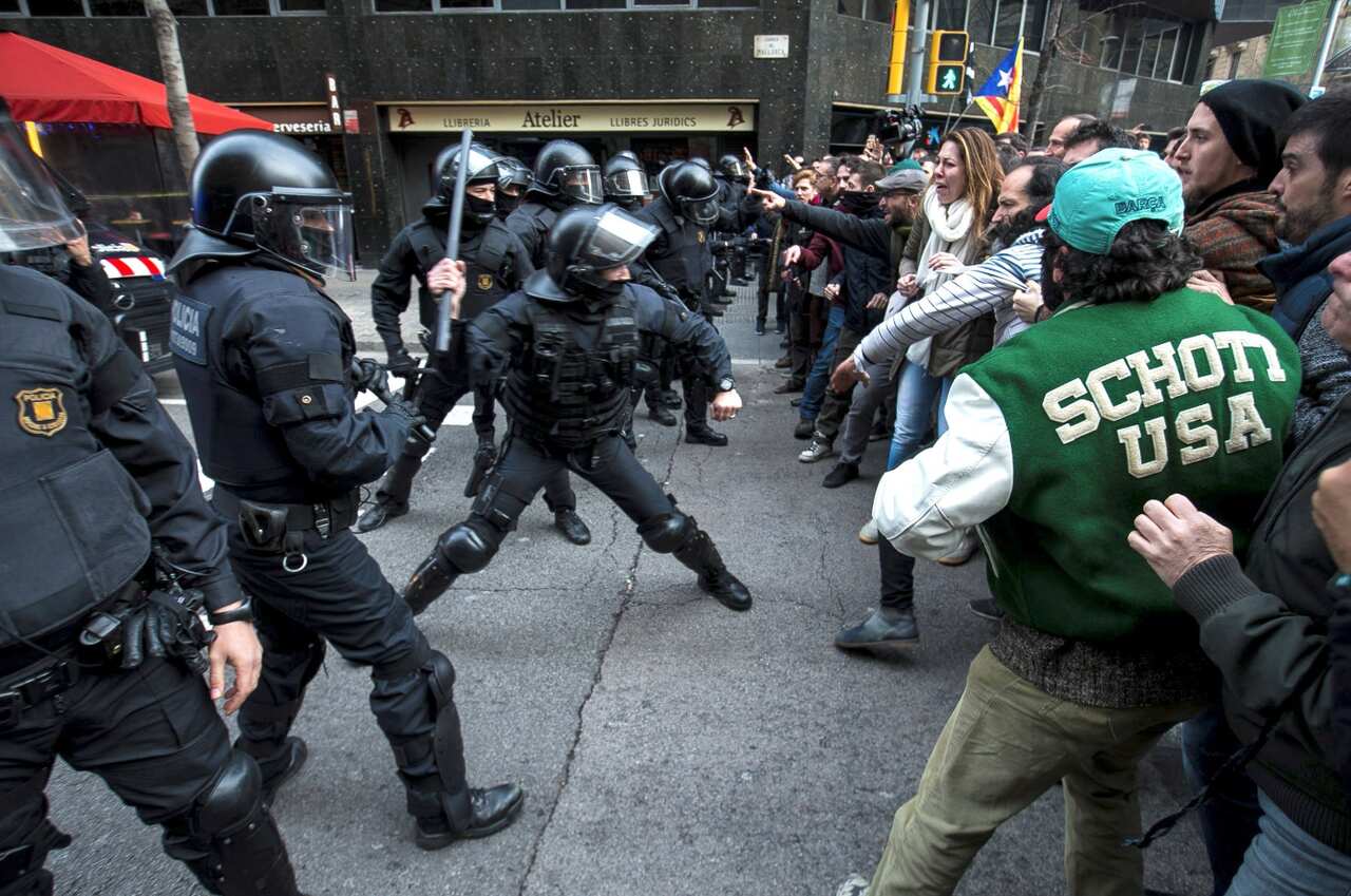 Riot police clash with pro-independence supporters trying to reach the Spanish government office in Barcelona. 