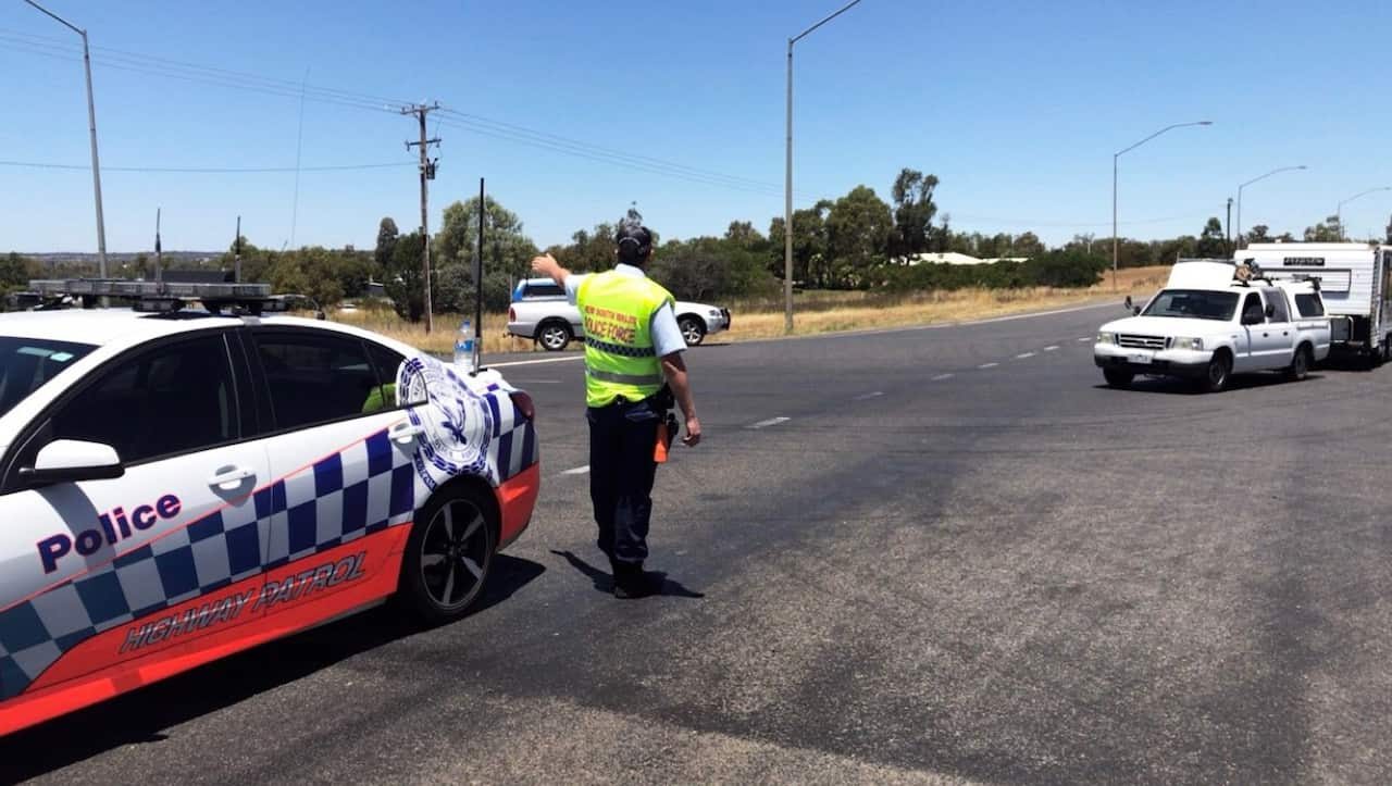 A NSW Police officer directing traffic at the scene of the crash (Lily Cardis/Twitter)