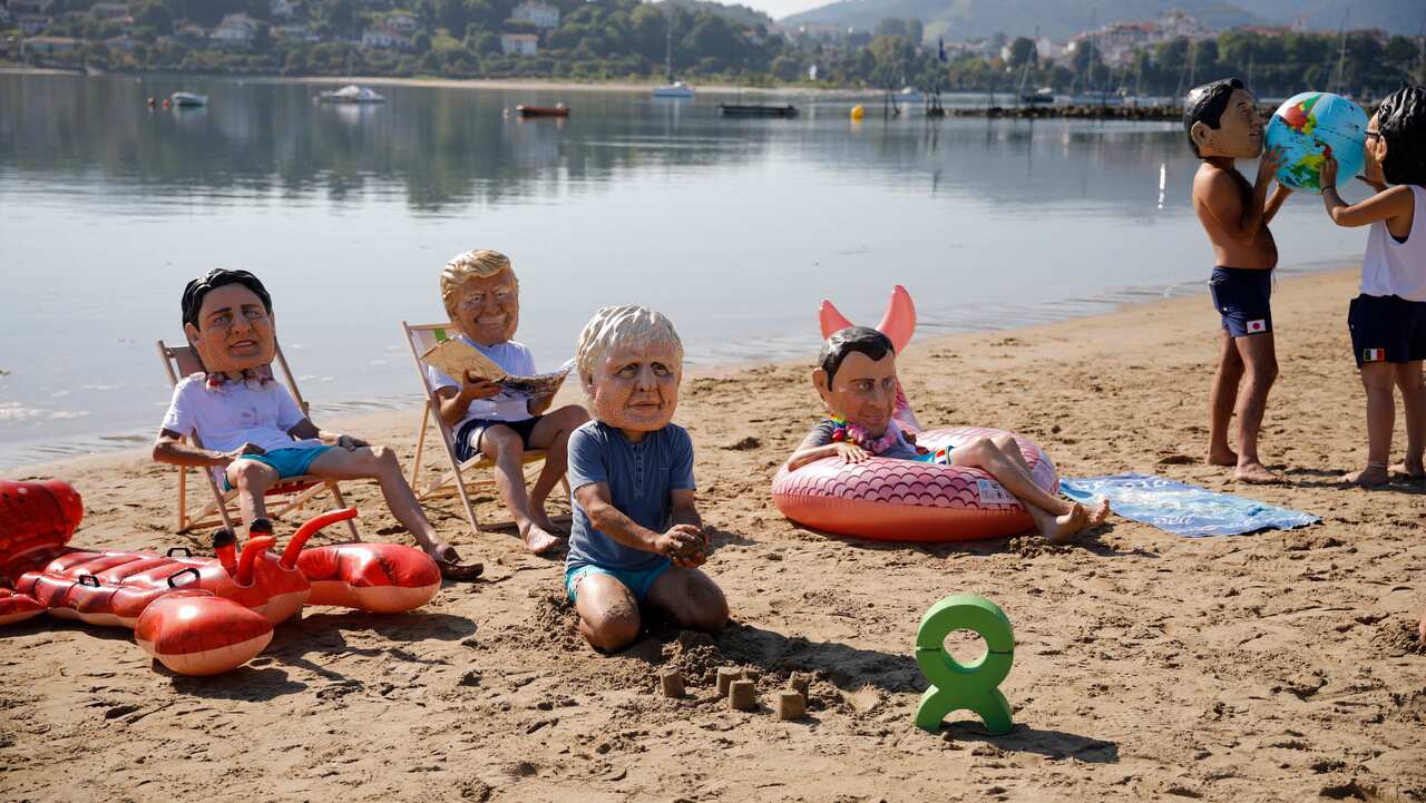Oxfam activists wear masks of the G7 leaders in Hendaye, France.