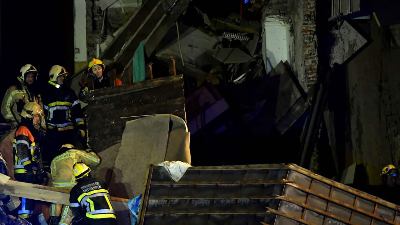 Firefighters inspect the collapsed building.