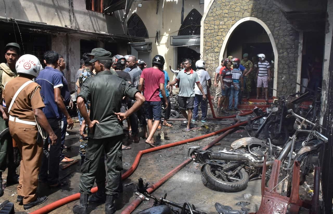 Locals and police gather at the Secon church Batticalova central road in Colombo, Sri Lanka, 21 April 2019. 