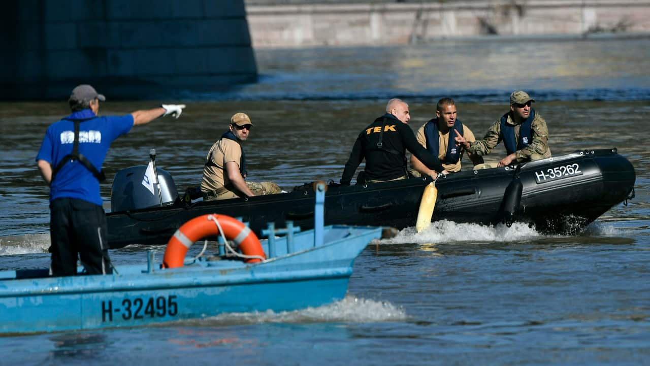 Members of the Hungarian Counter Terrorism Centre sit in a rubber dingy under Margaret Bridge, the scene of the accident.