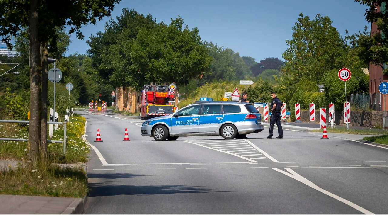 Police block the 'Travemuender Landstrasse' street near the scene where a person had allegedly attacked passengers on a bus in Luebeck, Germany, 20 July 2018.