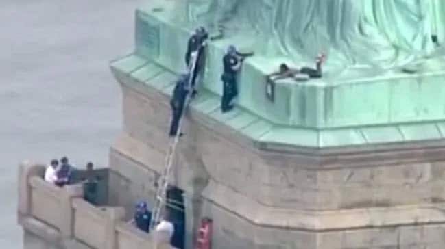 Police talking to a woman who climbed to the base of the Statue of Liberty.