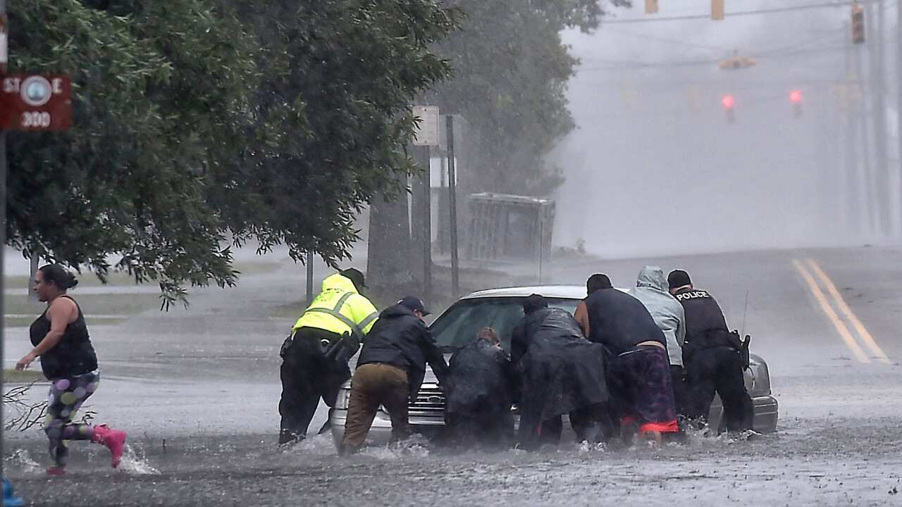 Civilians push a stranded motorist out of the flood water near downtown Lumberton, North Carolina.