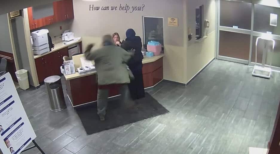 A man can be seen approaching the woman from behind, he then punches her multiple times in the head. 