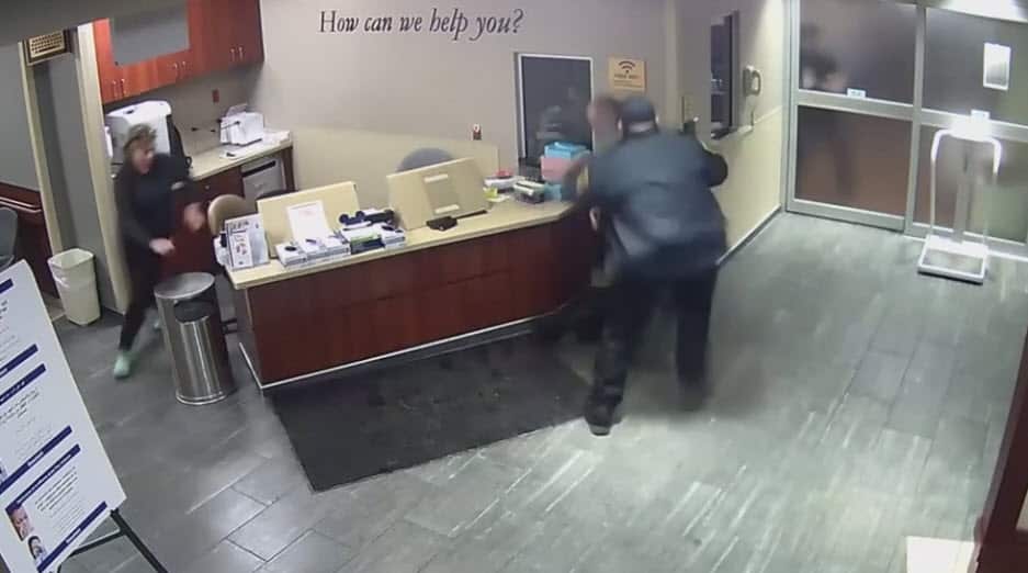 The receptionist is seen rushing to the aid of the woman, and a security guard restrains the accused. 