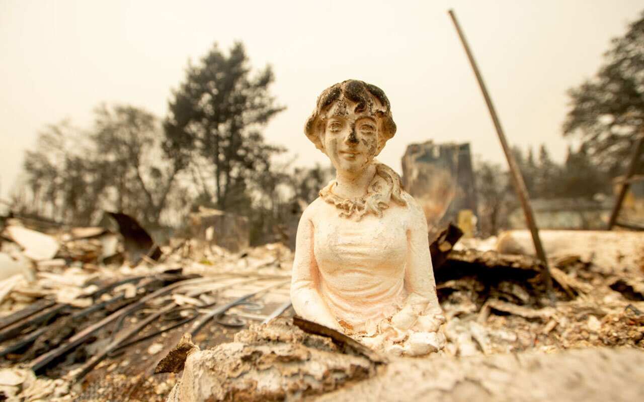 A charred statue is seen among the burned out remains of a residential neighborhood during the Carr fire in Redding, California on July 27, 2018. 