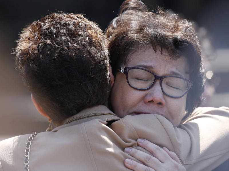 Selina Cheng, the wife of Curtis Cheng, is consoled by a friend after the funeral of her husband at St Mary's Cathedral in 2015.