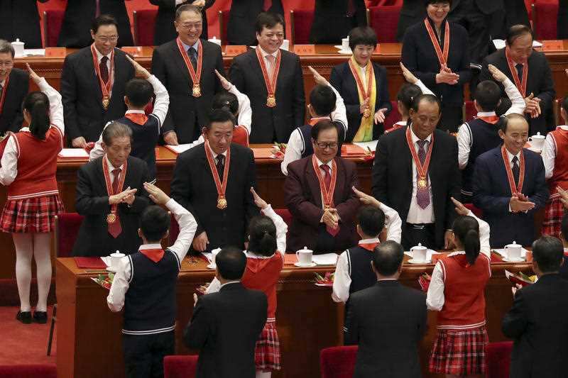 Children salute medallion recipients during the conference to commemorate the 40th anniversary of China's Reform and Opening Up policy.