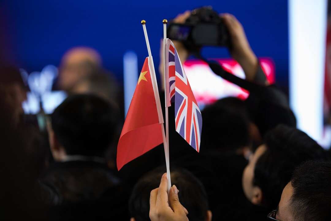 A visitor waves flags at a youth festival exhibition attended by British Prime Minister Theresa May.