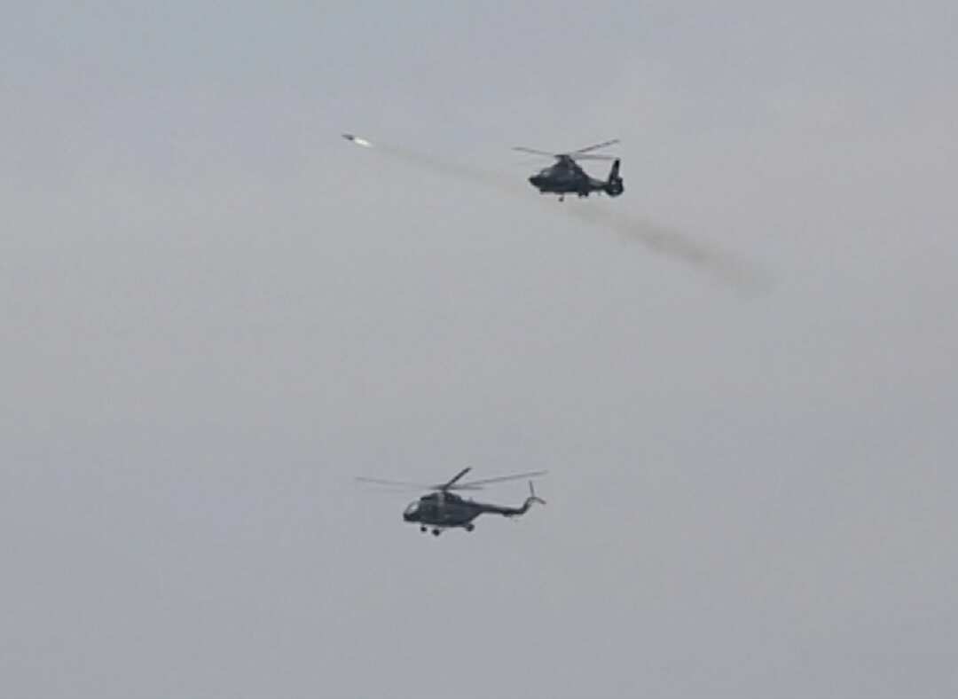 The helicopters fired missiles at distant objects in the water.