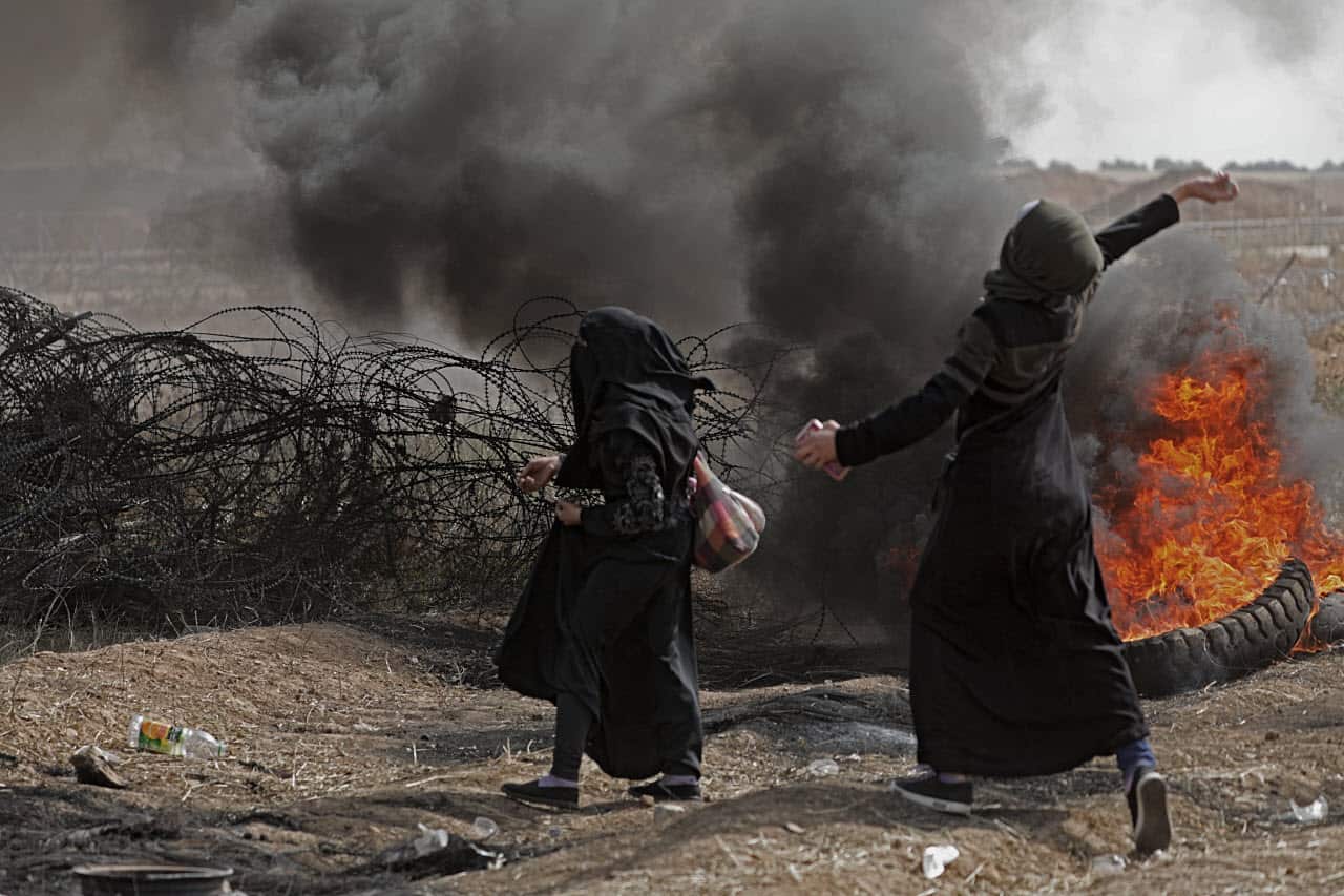 Palestinian women clash with Israeli troops near the border with Israel in the east of Gaza City on, 13 April 2018 