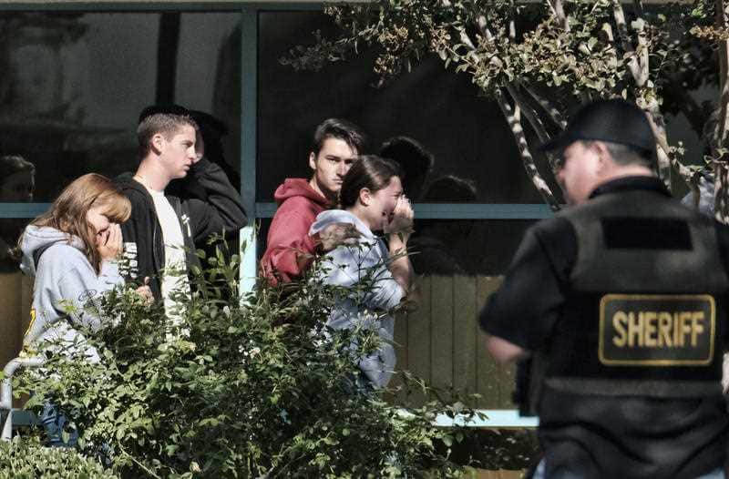 Grieving people are led into the Thousand Oaks Teen Center where families have gathered after the deadly shooting at a bar.