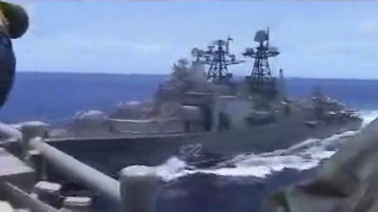 A Russian destroyer, left, sails very close to the USS Chancellorsville, right, while operating in the Philippine Sea.