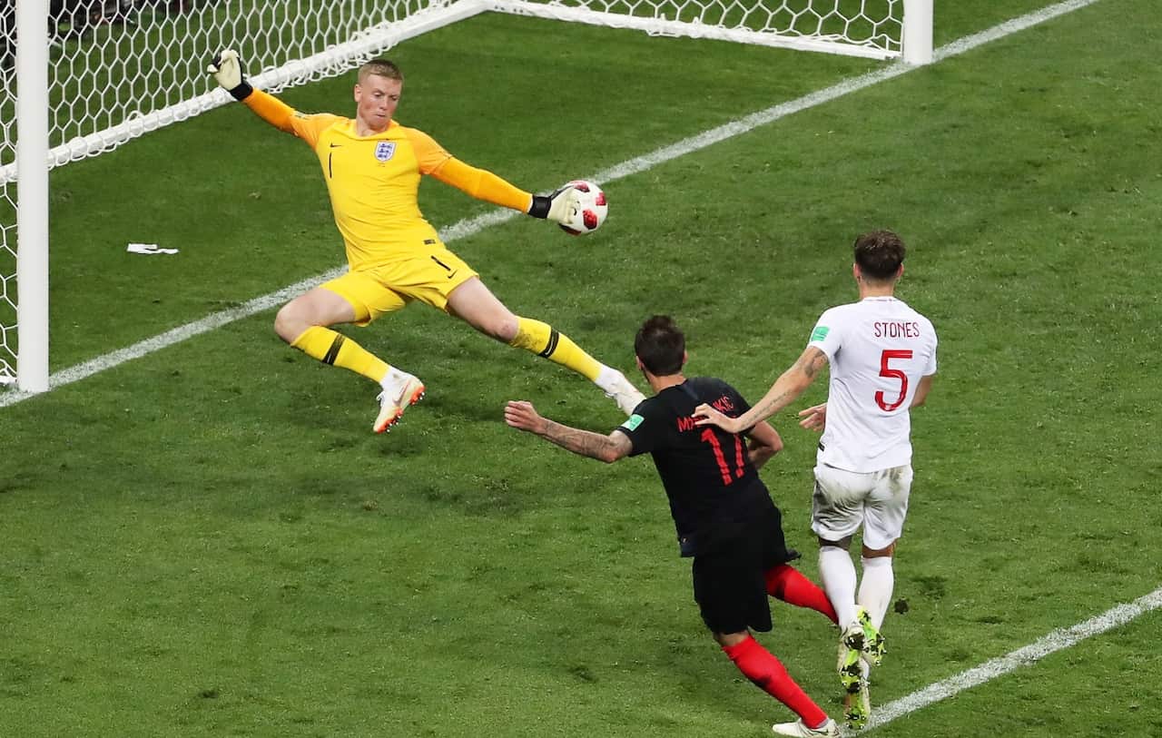 Mario Mandzukic (C) of Croatia scores the 2-1 lead against England's goalkeeper Jordan Pickford (L) during the FIFA World Cup 2018 semi final