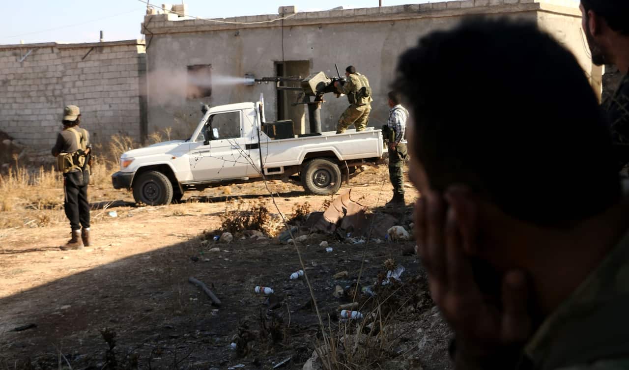 Free Syrian Army fire a machine gun mounted on a vehicle deploy during fighting against the Islamic State (IS) group jihadists