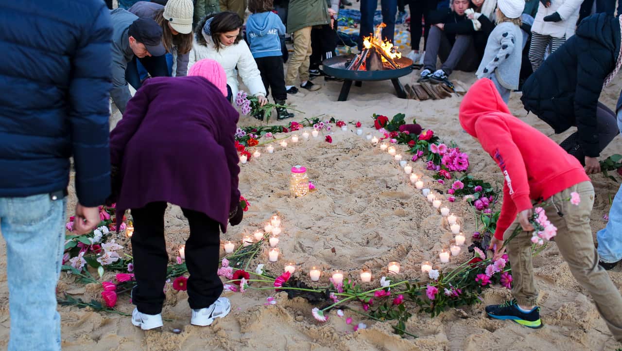 Family and friends lay flowers during a candlelight vigil for Justine Damond in Sydney.