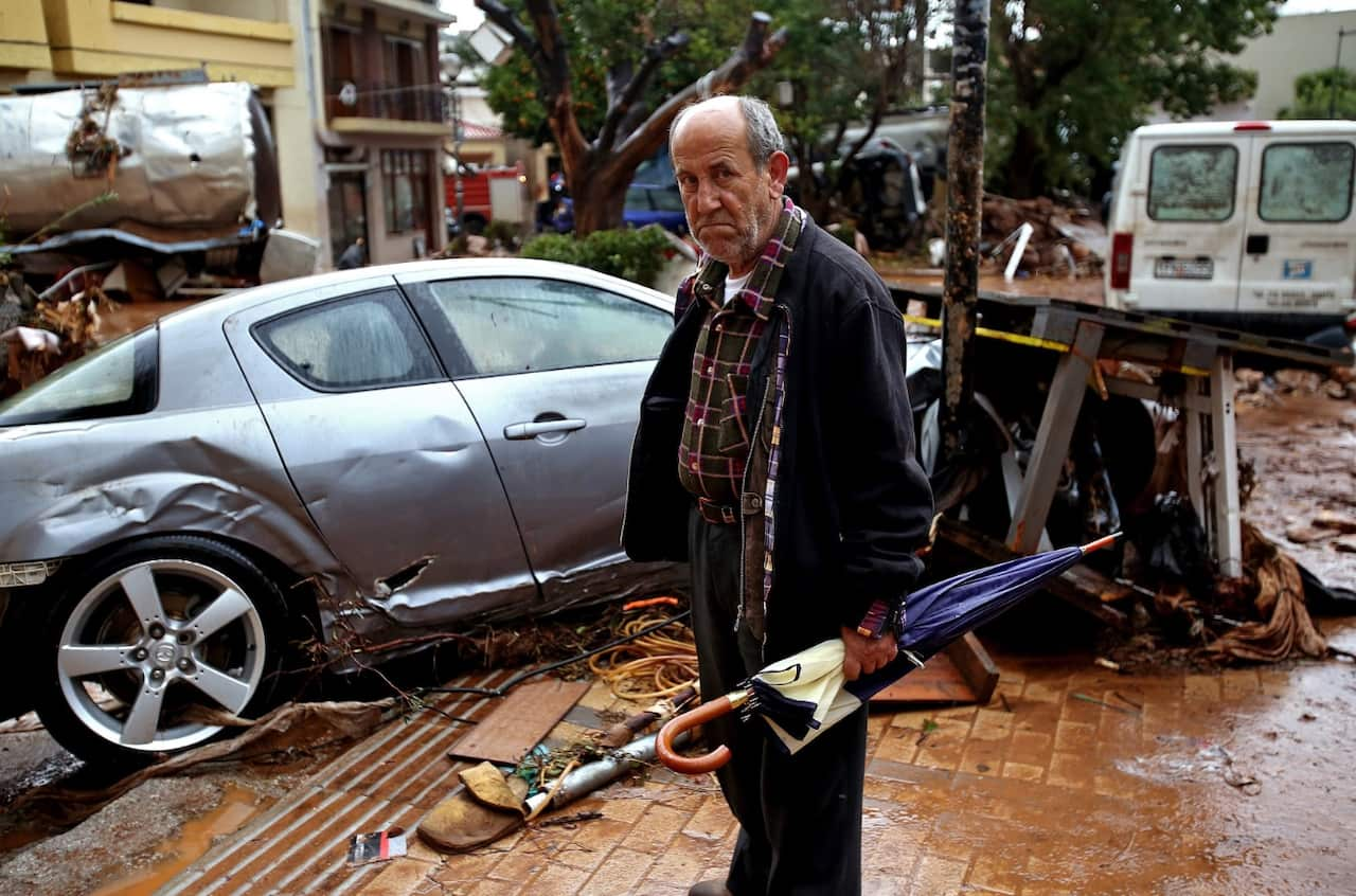 A man stands in front of destroyed cars in the center of Mandra, Western Attica, Greece 16 November 2017 (AAP)