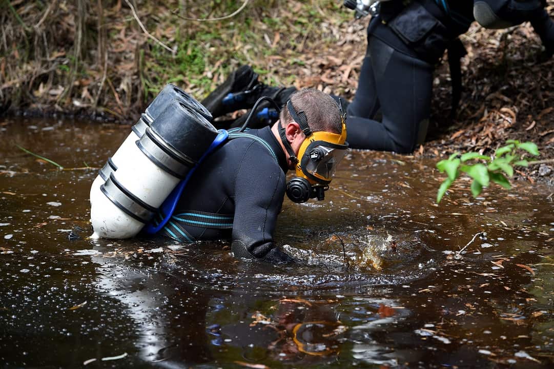 NSW Police divers search a dam.