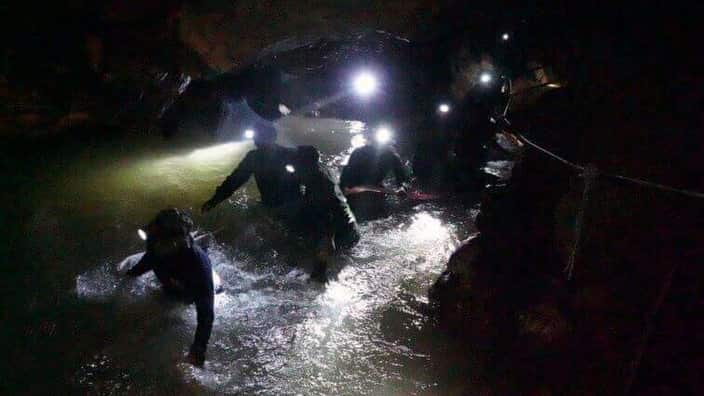 Thai rescue teams walk inside cave complex.