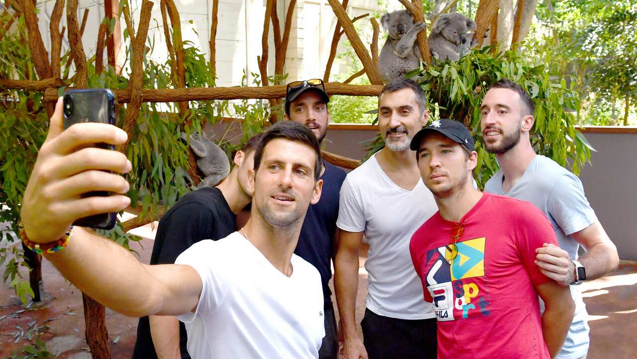 Novak Djokovic (left) of Serbia is seen taking a selfie photograph with team mates during a visit to the Lone Pine Koala Sanctuary in Brisbane.