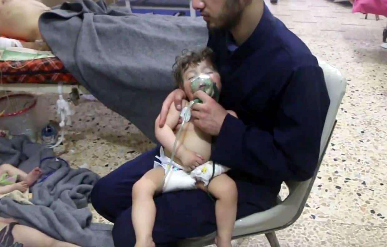 A medical worker giving toddlers oxygen through respirators following an alleged poison gas attack in the opposition-held town of Douma.