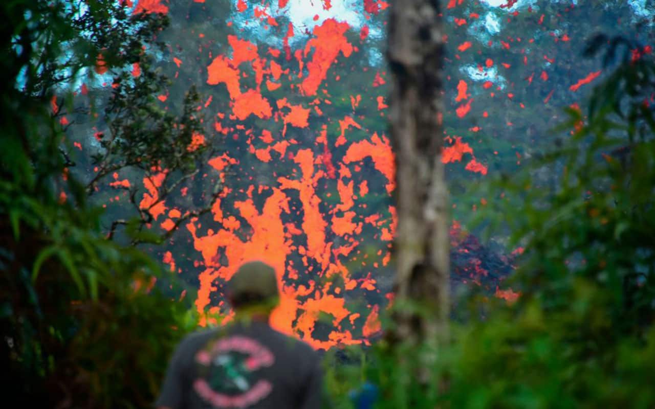 A man watches as lava is seen coming from a fissure in Leilani Estates subdivision on Hawaii's Big Island on May 4, 2018.
