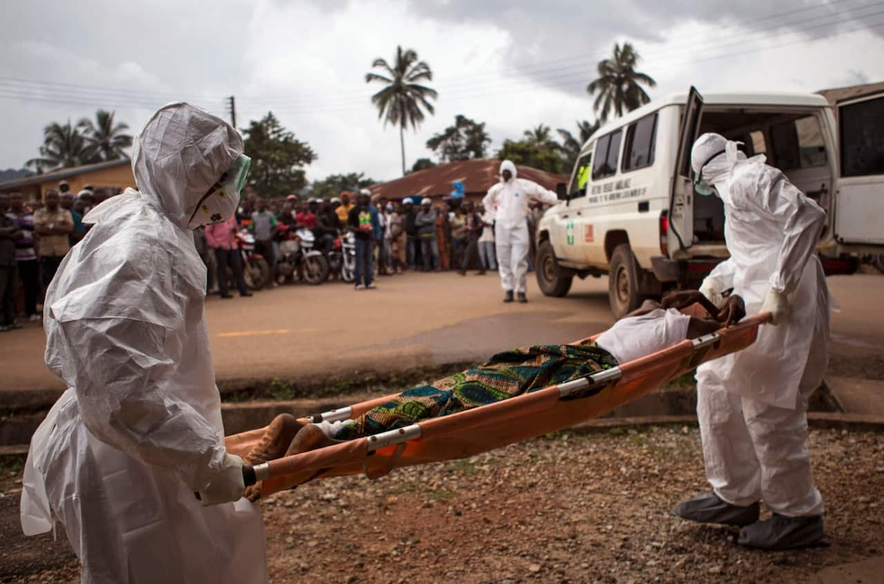 File image from 2014 of healthcare workers loading a man suspected of suffering from the Ebola virus onto an ambulance in Sierra Leone (AAP)