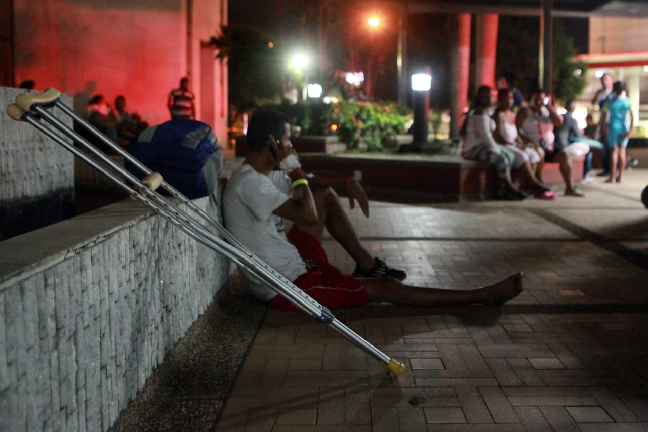 A group of patients is evacuated from a clinic due to the presence of cracks in the building following a strong earthquake in Ecuador