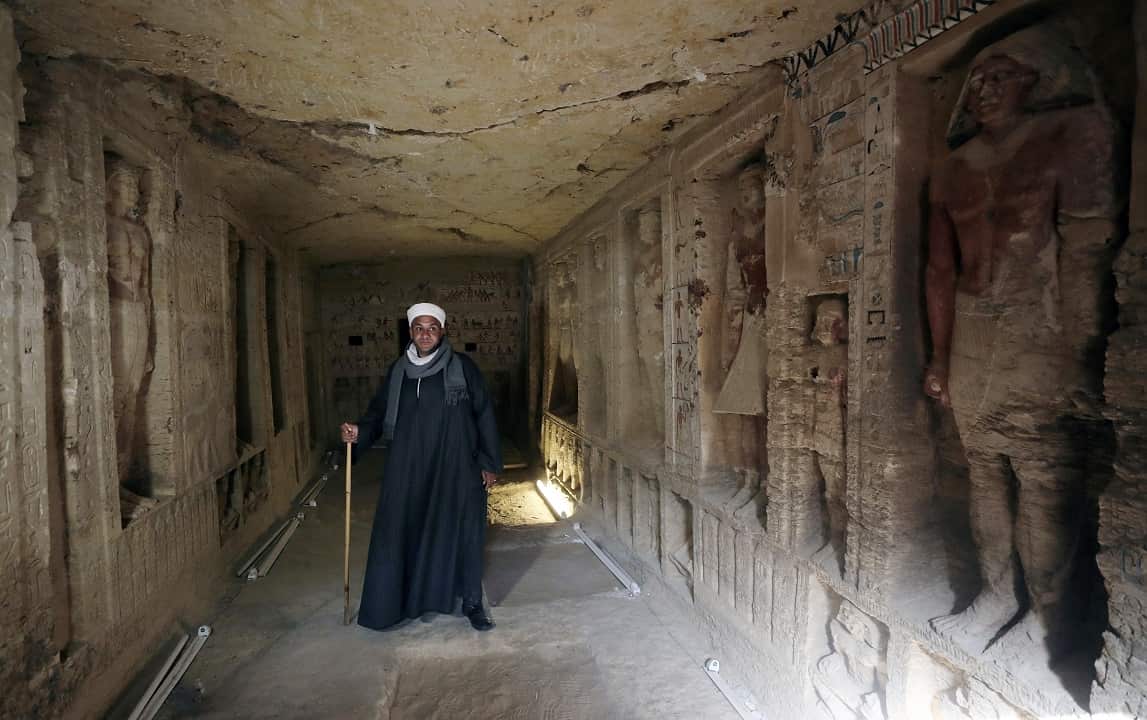 An Egyptian archaeological worker stands inside the newly-discovered tomb of 'Wahtye'.
