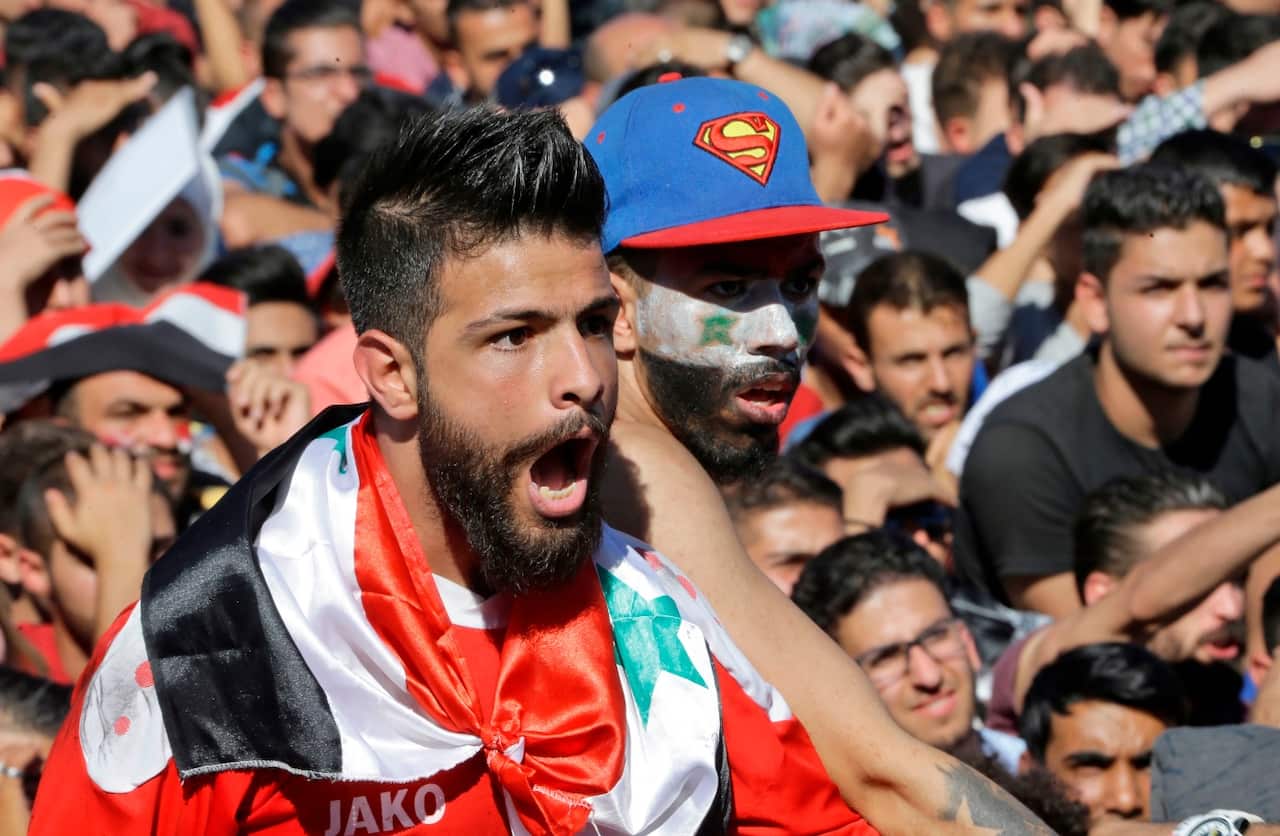 Syrians cheer on their national team at the Umayyad Square in Damascus (Getty)