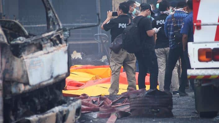 Indonesian forensic policemen work after a fire disaster in Tangerang Kota, Banten province on October 26, 2017.