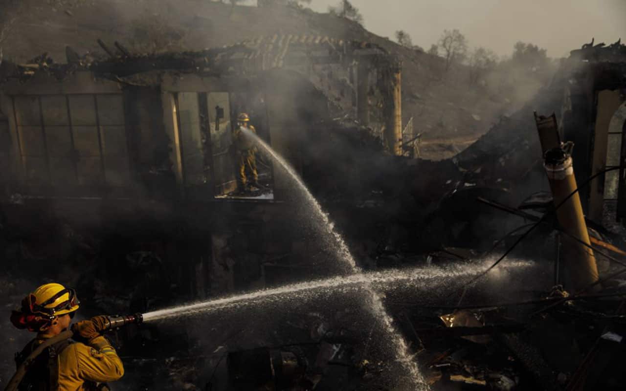 Humboldt County firefighters Lonnie Risling, left, and Jimmy McHaffie, right, spray down smoldering fire.